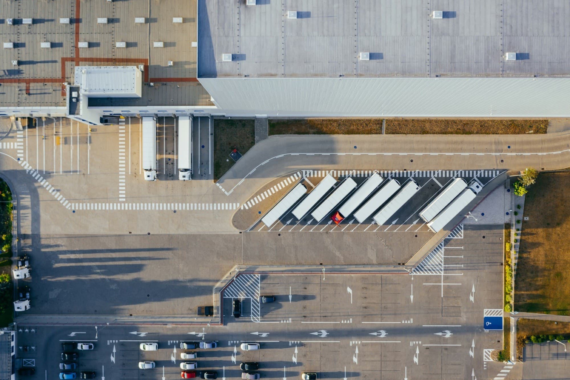 Aerial view of a logistics yard with trailers lined up at the loading bays